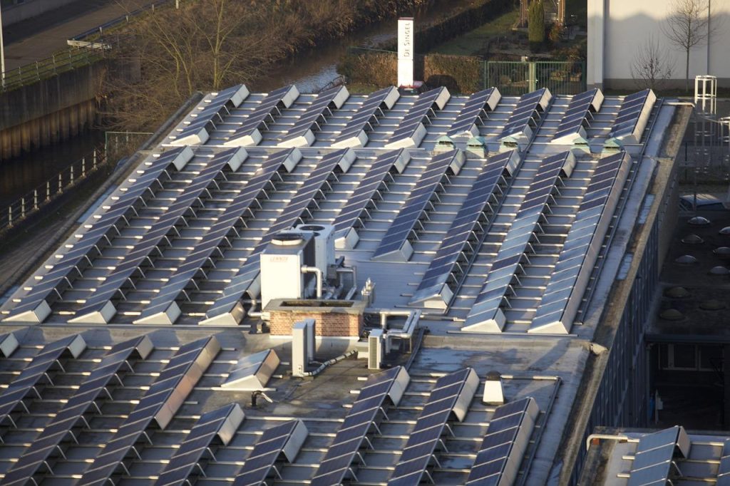 Professional voert dak- en gevelwerken uit op hoogtes met volledige veiligheidsuit en demonstreert vakmanschap