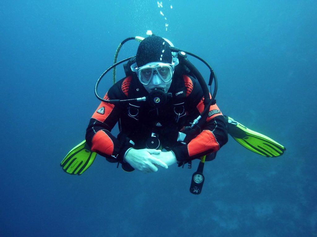Kind draagt complete snorkeluitrusting met duikbril, snorkel en zwemvliezen voor onderwaterverkenning
