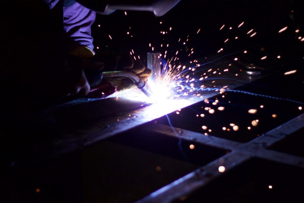 Medewerker voert kwaliteitscontrole uit op metalen component ter voorkoming van productiefouten in metaalbewerking